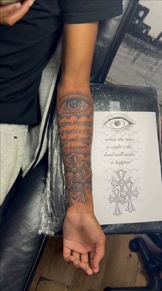 a person with a tattoo on their arm holding a piece of paper in his hand