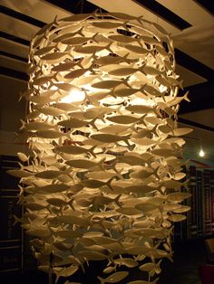 a large light fixture made out of paper fish