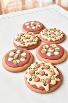 four decorated cookies sitting on top of a table