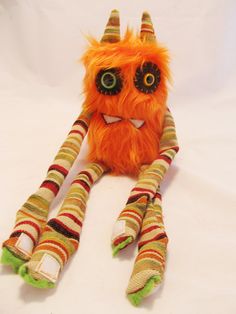 an orange stuffed animal with big eyes and long legs