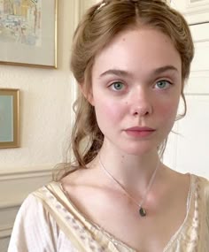 a woman in a white dress is wearing a necklace and looking at the camera with an intense look on her face