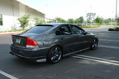 a grey car parked in a parking lot next to a building with no people on it