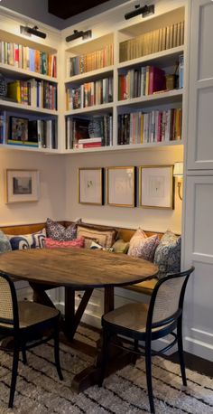 a living room filled with furniture and bookshelves next to a dining room table