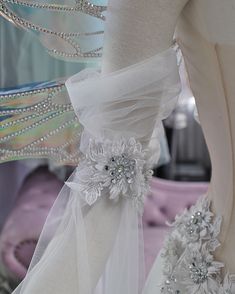 a white dress with flowers and ribbons on it