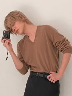 a woman is holding a camera and posing for the camera with her hands behind her head