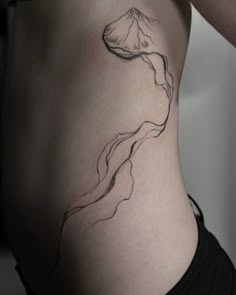 a woman's stomach with a mountain tattoo on the side and her lower back