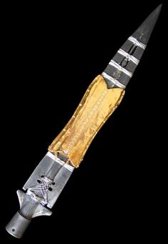 an old knife that has been cut in half with gold and silver foil on it