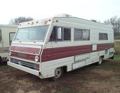 an old camper is parked in a field