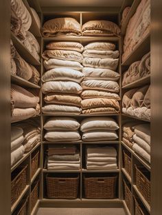 a closet filled with lots of linens and pillows in baskets on the floor next to each other