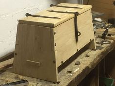 a large wooden box sitting on top of a workbench with tools in it