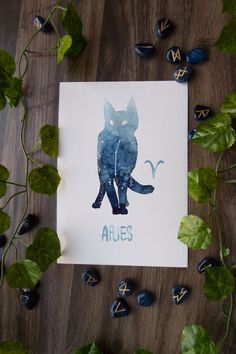 a card with an image of a cat and the word aries written in blue ink