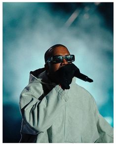 a man with sunglasses on his face and hands in the air