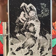 a person holding up a black and white drawing