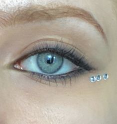 simple blue eyes black eyeliner Under Eye Gems, Black Gem Eye Makeup, Black Gems Makeup, Black Eyeliner With Gems, Blue Eyes Eyeliner, Black Eyeliner Blue Eyes, Black Water Line Eye Makeup, Tiny Rhinestone Makeup, Black Eyeshadow With Rhinestones