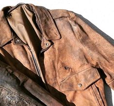 an old leather jacket is laying on the ground