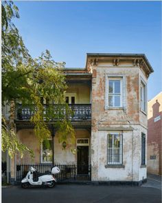 a scooter is parked in front of an old building with balconies