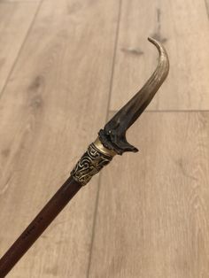an old fashioned wooden handle with metal decoration on the tip and long horns attached to it