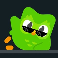 a green monster with big eyes sitting on top of a table