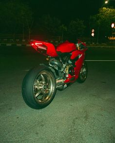 a red motorcycle parked on the street at night