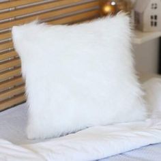 a white fluffy pillow sitting on top of a bed