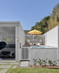 a car is parked in front of a house with an outdoor jacuzzi tub