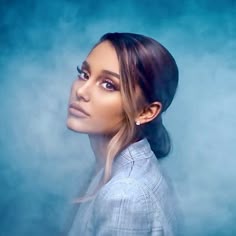 a woman with her hair in a ponytail looking off to the side and into the distance