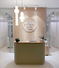 the front desk of an office with lights hanging above it