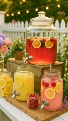 several jars filled with lemons, raspberries and strawberries on top of a table