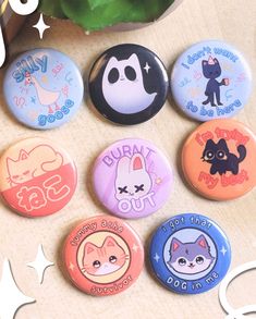 there are six buttons on the table with cats and other things around them that say hello kitty