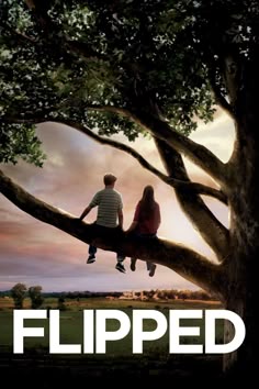 a couple sitting on top of a tree with the words flipped in front of them