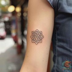 a woman's arm with a tattoo design on the left side of her arm