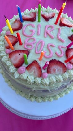 a birthday cake with strawberries and candles on it that says girl boss written in white frosting