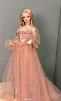 a doll wearing a pink dress and veil