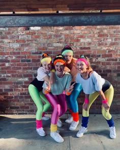 four girls in colorful leggings posing for the camera with their arms around each other