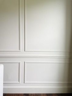 an empty room with white walls and wood floors