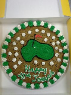 a decorated birthday cake in the shape of a golf green and white circle with happy new year written on it