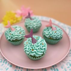 three cupcakes with green frosting on a pink plate