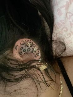 a woman with black hair and leopard print on her ear