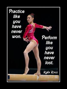 a woman in a red leotard on a balance beam