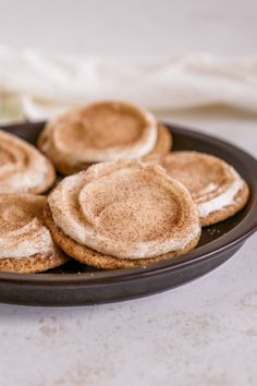 some cookies are sitting on a plate with white frosting and cinnamon in the middle