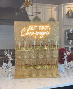 there are wine glasses on the counter in front of this sign that says, but first champagne
