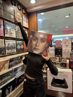 a woman is holding up a record player