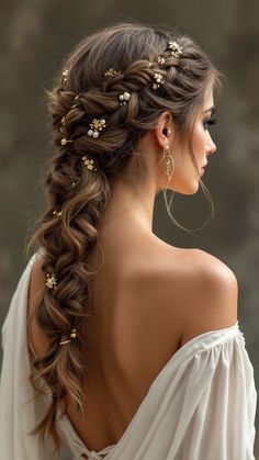 a woman with long hair wearing a white dress and gold flowers in her hair is looking off to the side