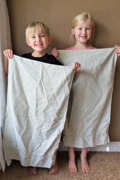 two young children holding up some white sheets