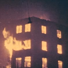 the building is lit up at night with many windows and lights shining on it's side