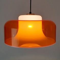 an orange light hanging from a ceiling fixture