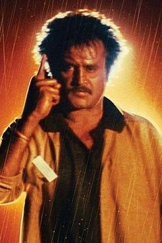 a man holding a cell phone up to his ear while standing in the pouring rain