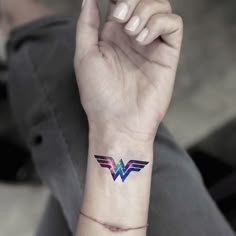a woman's arm with a small tattoo design on the left side of her wrist