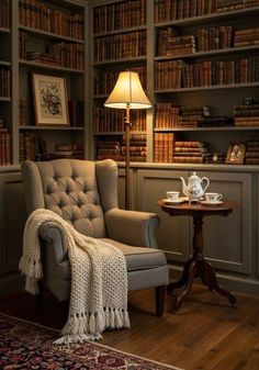 a chair with a blanket on it in front of a book shelf filled with books