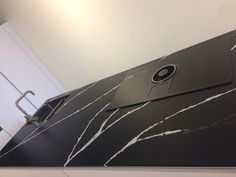 a black and white marble counter top with a cell phone on it's side